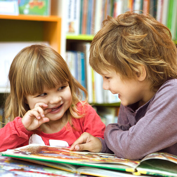 Two Young Children Reading In A Library